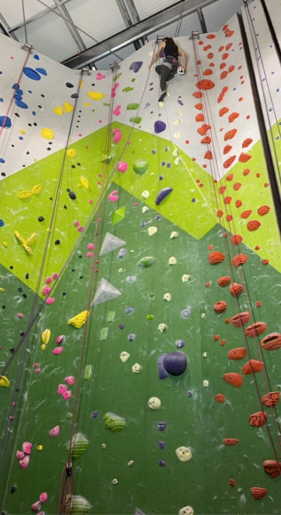 woman top rope climbing near the top of the wall