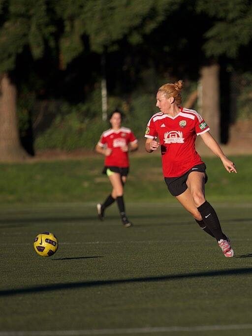 woman playing soccer outdoors